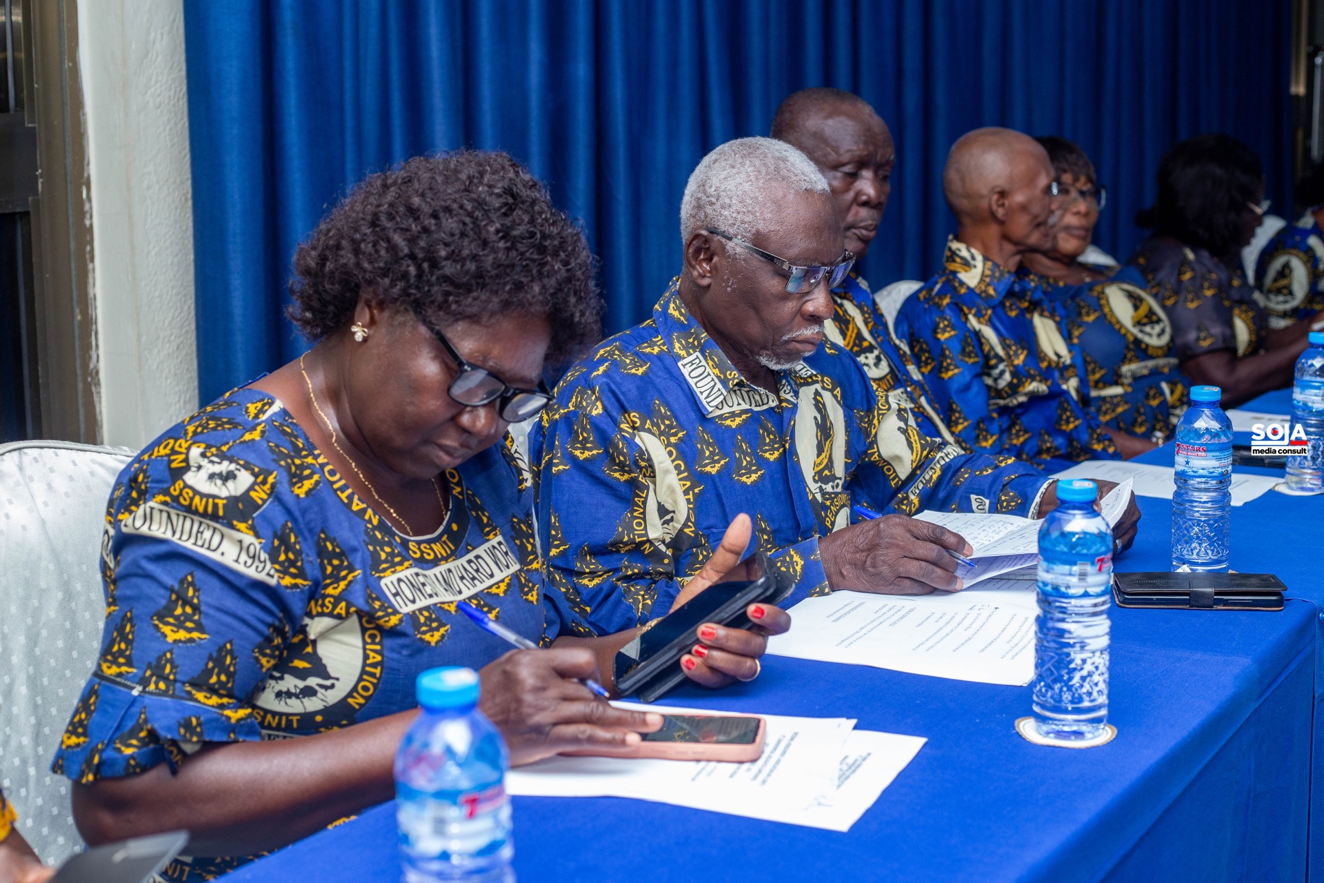 Association members in NPA cloth seated at a conference table reviewing papers