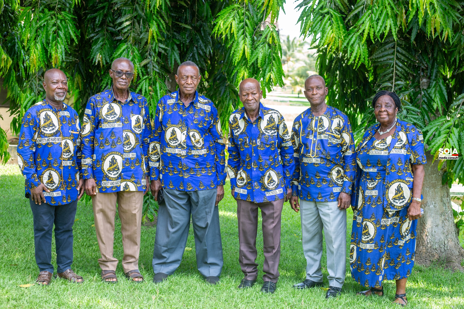 Six Association members in blue NPA cloth standing together on the grass
